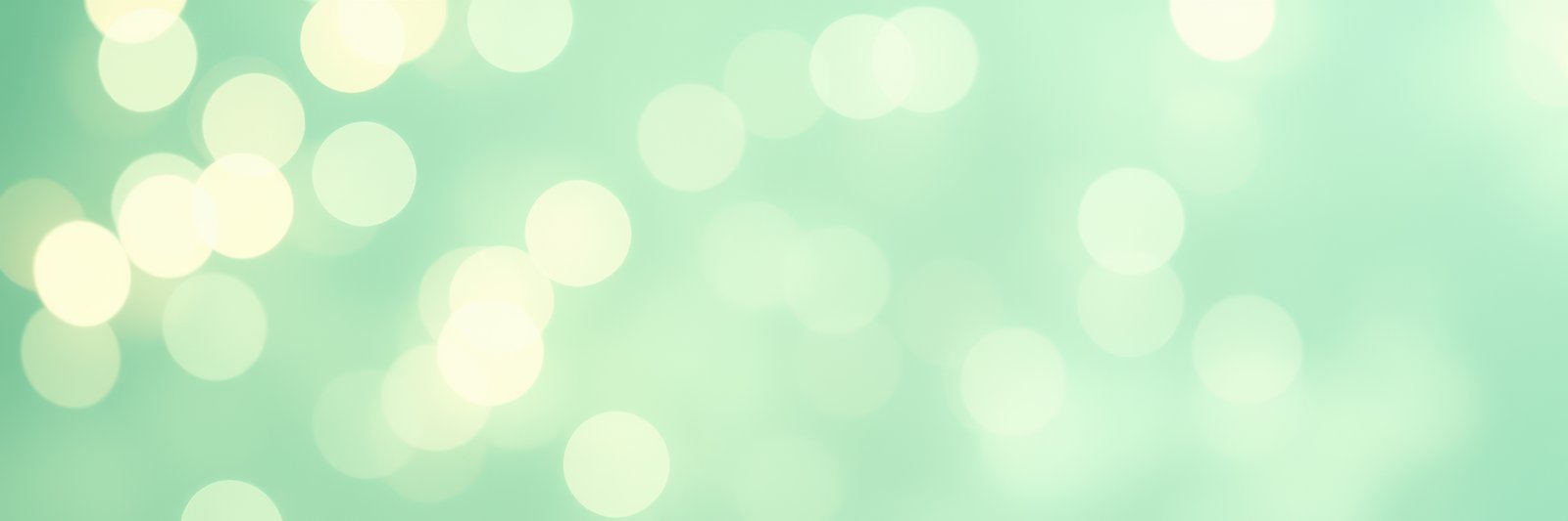Soft green bokeh background with light reflections creating a serene atmosphere for design